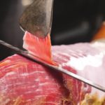 Experto cortando una loncha fina de jamón